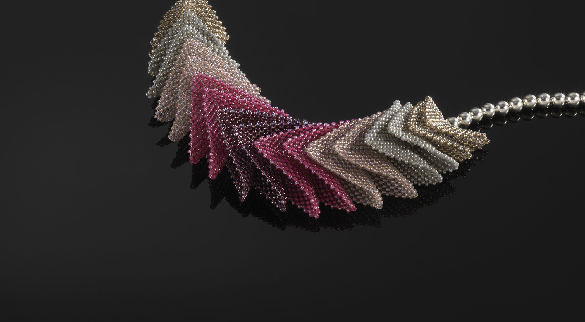 Origami—Hand-stitched triangular seeded beads and sterling silver beads.